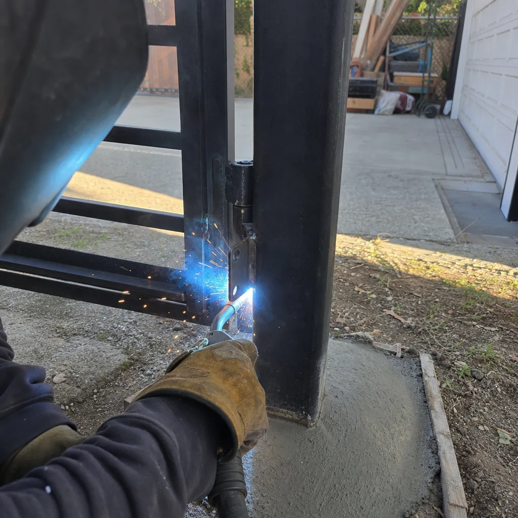 Professional technician performing custom metal gate repair and hinge welding installation